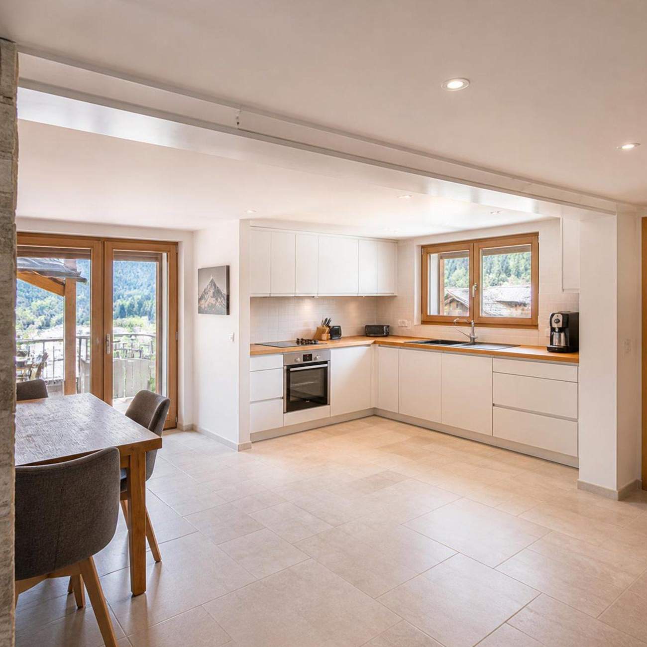 Cuisine ouverte rénovée avec grand carrelage et menuiseries bois, Hautes-Alpes